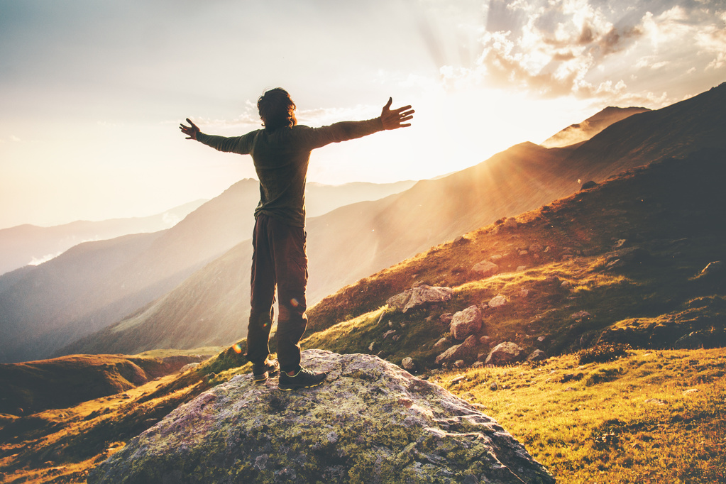 Happy Man raised hands at sunset mountains Travel Lifestyle emotional concept